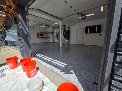 A finished garage floor in gray and black flake under a gloss topcoat